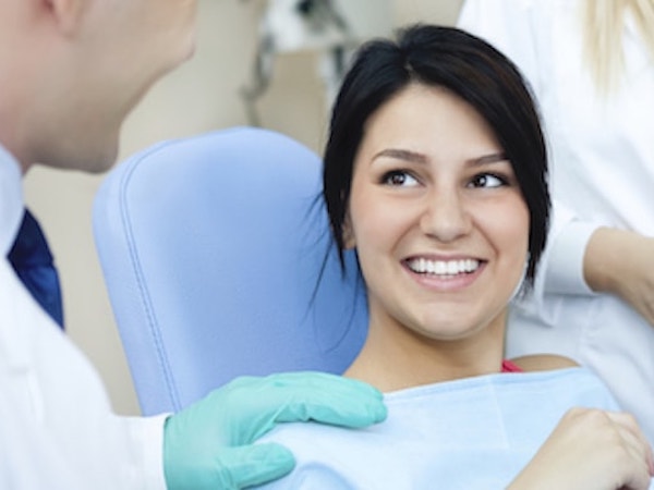 Woman with dark hair sitting in dental chair about to choose from our services