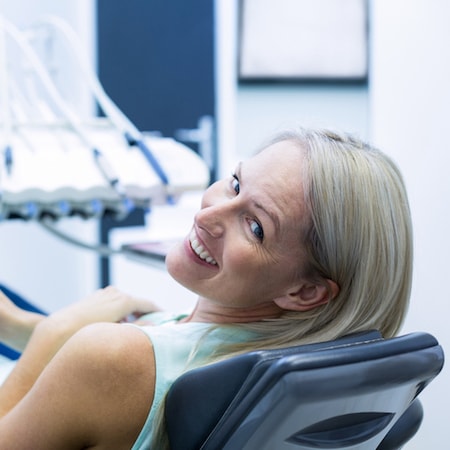 Woman laying on a dental treatment chair as she waits to receive family dentistry